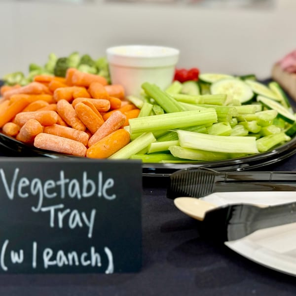 A vegetable tray with baby carrots, celery sticks, and ranch dip, labeled "Vegetable Tray (w/ Ranch)".